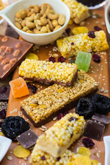 Granola Bars and mixed nuts. Honey bars with peanuts, chocolate, dried fruit, sesame and sunflower seeds
