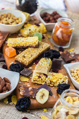 Granola Bars and mixed nuts. Honey bars with peanuts, chocolate, dried fruit, sesame and sunflower seeds