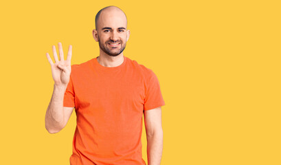 Young handsome man wering casual t shirt showing and pointing up with fingers number four while smiling confident and happy.