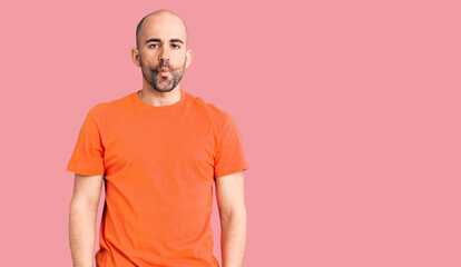 Young handsome man wering casual t shirt making fish face with lips, crazy and comical gesture. funny expression.