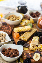 Granola Bars and mixed nuts. Honey bars with peanuts, chocolate, dried fruit, sesame and sunflower seeds