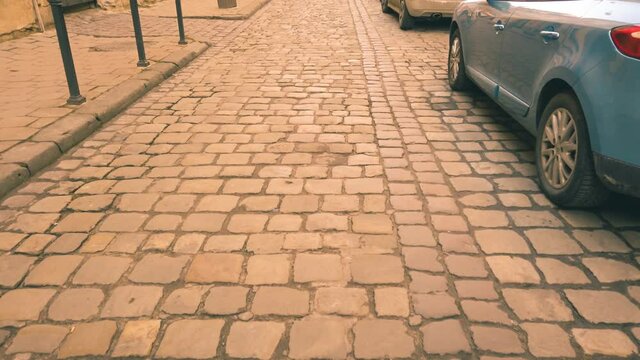 Old street of paving stone and parked cars.