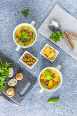 Healthy delicious vegetable soup puree with carrot chips and croutons. Served on grey table surface.