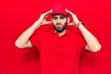 Young handsome man with beard wearing casual polo and cap with hand on head, headache because stress. suffering migraine.