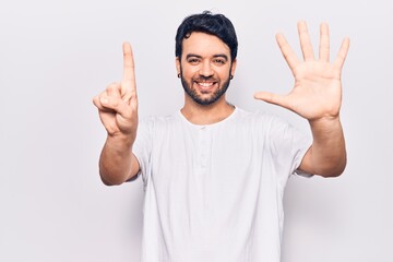 Young hispanic man wearing casual clothes showing and pointing up with fingers number six while smiling confident and happy.