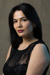 Portrait of a young sexy brunette girl in a lace top in dramatic tones. Vintage photo.