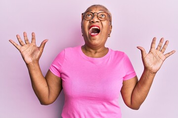 Senior african american woman wearing casual clothes and glasses crazy and mad shouting and yelling...