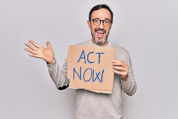 Middle age handsome man asking for rights holding banner with act now message celebrating achievement with happy smile and winner expression with raised hand