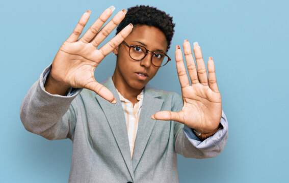 Young african american woman wearing business clothes doing frame using hands palms and fingers, camera perspective