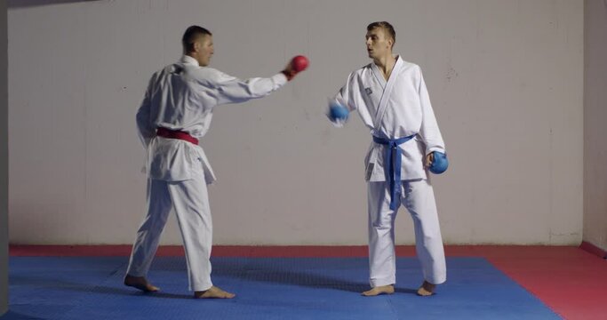 2 karate men training in an indoor gym