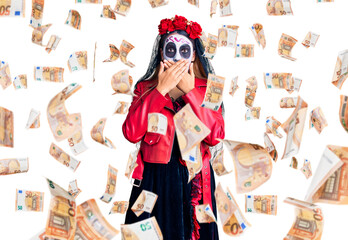 Woman wearing day of the dead costume over background shocked covering mouth with hands for mistake. secret concept.