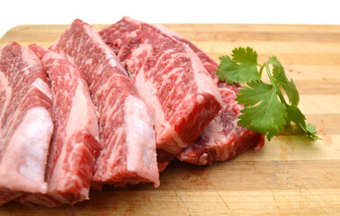 raw beef ribs on wooden board