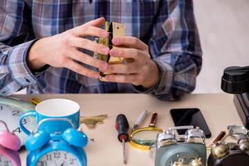 Young male watchmaker working in the workshop