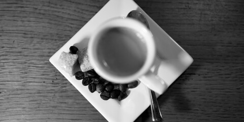 Obraz premium Filiżanka aromatycznego espresso zatopiona w czarno-białej nucie ciepła.
