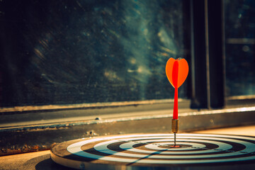 Dart arrow hit on bulleyes of dartboard to represent that the business reached the target  with...