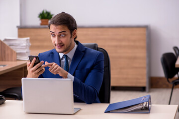 Young male employee unhappy with excessive work in the office