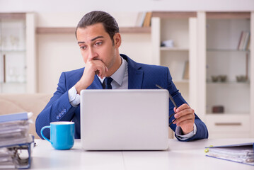 Young male employee working from home in pandemic concept