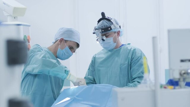 Operation of removing tonsils, tonsillectomy under deep anesthesia, using latest devices, cold plasma method, cuts swelling in throat, doctor works with new probe, medical headlamp, surgical loupes