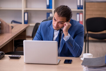 Young sick businessman employee suffering at workplace