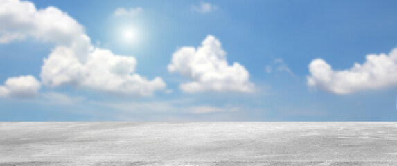 Raw cement or concrete outdoor floor shelf is blank template with natural blue sky and clouds blur...