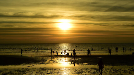 Beautiful golden yellow sky and sun The view of the beach, the beach and the sun loungers are rising. Beautiful golden yellow sky and sun