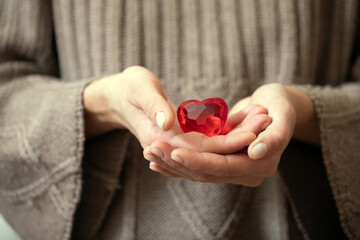 Woman valentines day. Love concept. Woman hand holding red heart. Toy. 