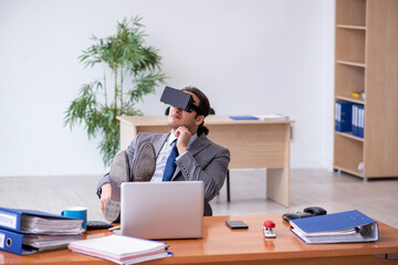 Young male employee wearing virtual glasses in the office