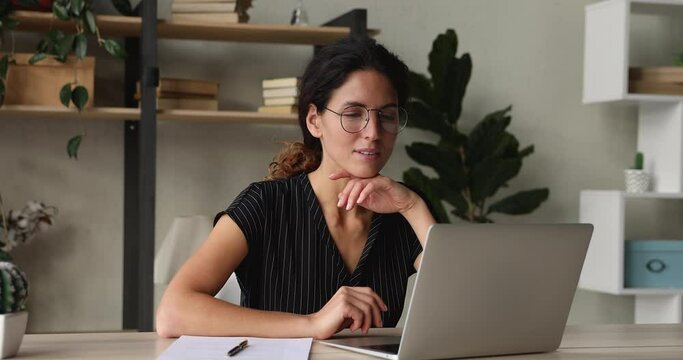 Attractive Millennial Business Lady Company Employee Sit At Workplace Desk Texting On Laptop Do Paperwork Writing On Paper Information Feels Satisfied By Fruitful Busy Workday In Modern Office Room