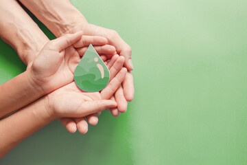 Hands holding paper cut green oil drop, CSR, alternative biofuel, algae fuel, renewable green...