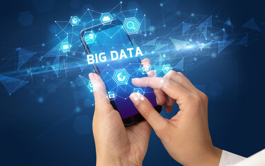 Female hand holding smartphone with BIG DATA inscription, modern technology concept