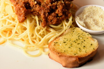 Fresh pasta Bolognaise served with green basil leaves on white plate
