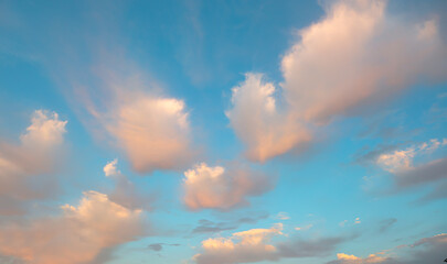 Blue sky and white clouds background - Pillowy clouds cover a blue sky in the background