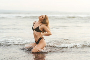 Fototapeta na wymiar Young female enjoying sunny day on tropical beach Bali Indonesia
