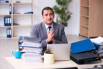 Fototapeta premium Young male employee unhappy with excessive work