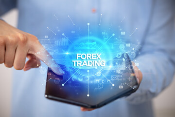 Fototapeta premium Businessman holding a foldable smartphone with FOREX TRADING inscription, new business concept