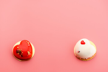 A cake in heart shape. Two cupcakes in the shape of a heart on a pink background, in the middle is a place for text, copy space. Valentine's Day.
