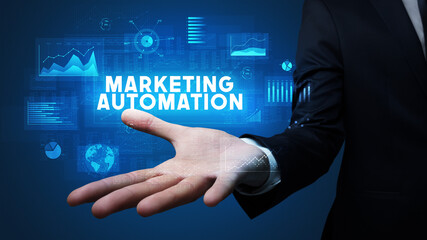 Hand of Businessman holding MARKETING AUTOMATION inscription, business success concept