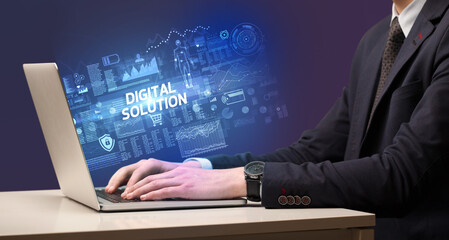 Businessman working on laptop with DIGITAL SOLUTION inscription, cyber technology concept