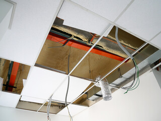 KUALA LUMPUR, MALAYSIA -JULY 24 2020: The suspended ceiling, electrical wiring, cabling and mechanical equipment under installation.  It is hanging at the floor soffit. Cover by ceiling board. 