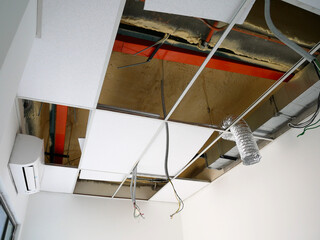 Fototapeta na wymiar KUALA LUMPUR, MALAYSIA -JULY 24 2020: The suspended ceiling, electrical wiring, cabling and mechanical equipment under installation. It is hanging at the floor soffit. Cover by ceiling board. 