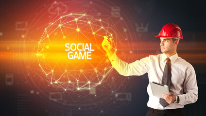 Handsome businessman with helmet drawing SOCIAL GAME inscription, social construction concept