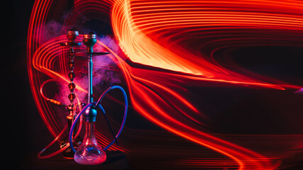 two hookahs with shisha coals and smoke with red and blue neon lighting