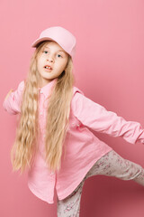 Little girl in pink clothes and a medical mask on a pink background