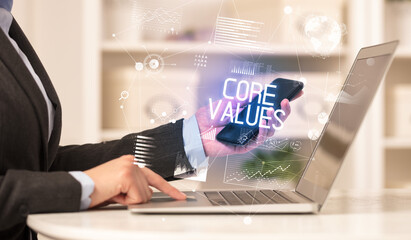 Side view of a business person working on laptop with CORE VALUES inscription, modern business concept