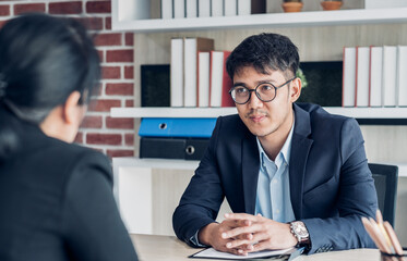 young asian businessman and businesswoman talking about business agreement at meeting table in modern office.business partnership concept.satisfied the deal with client negotiation - obrazy, fototapety, plakaty