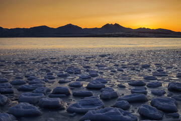 Obraz premium Frozen fjord waters at sunset, Tromso, arctic Norway