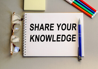 SHARE YOUR KNOWLEDGE. The notebook with text . Colored pencils and eyeglasses. Concept photo for...