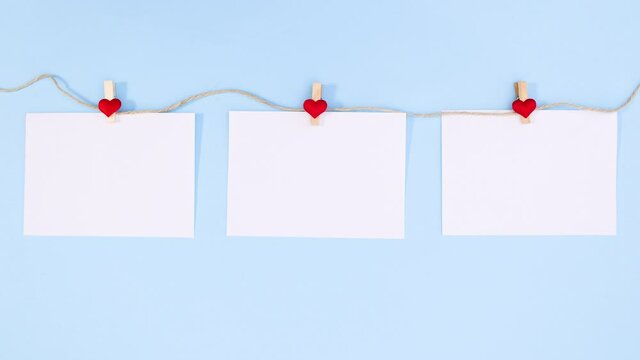 Papers for valentine's day text appear and hook on rope. Stop motion