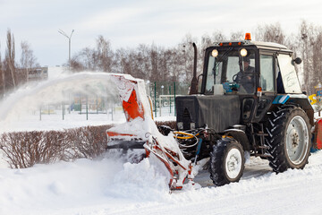 Tractor removes snow from city streets after snowfall. Russia