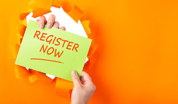 hand holding green sheet with REGISTER NOW through hole in ripped orange paper.